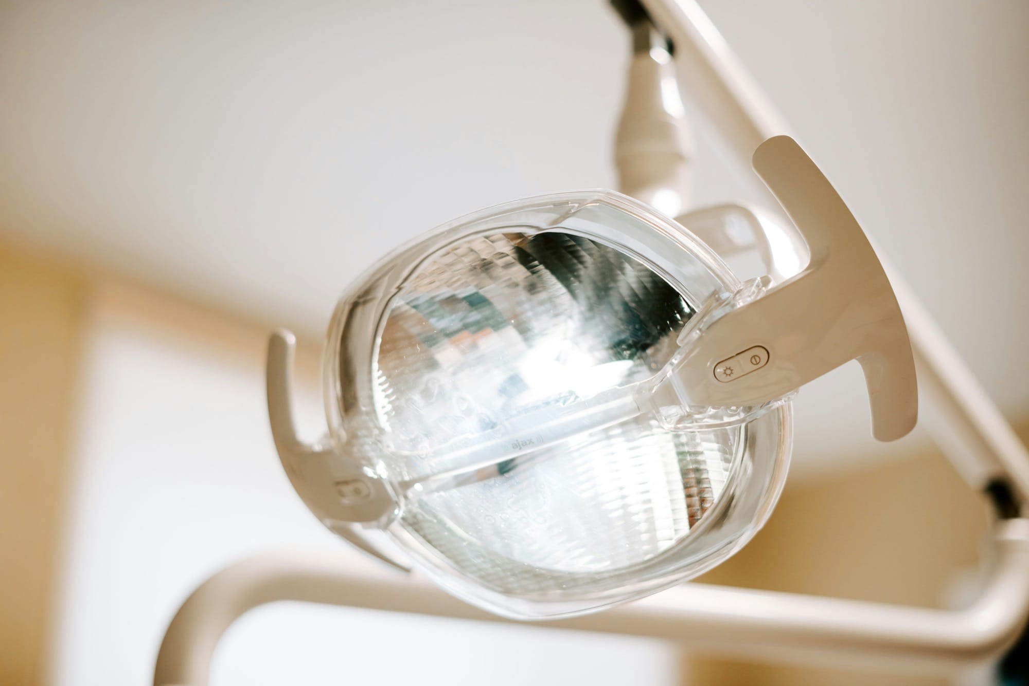 Deckenlampe im Behandlungsraum: Eine Zahnarztlampe hängt über dem Stuhl und sorgt für optimale Ausleuchtung.