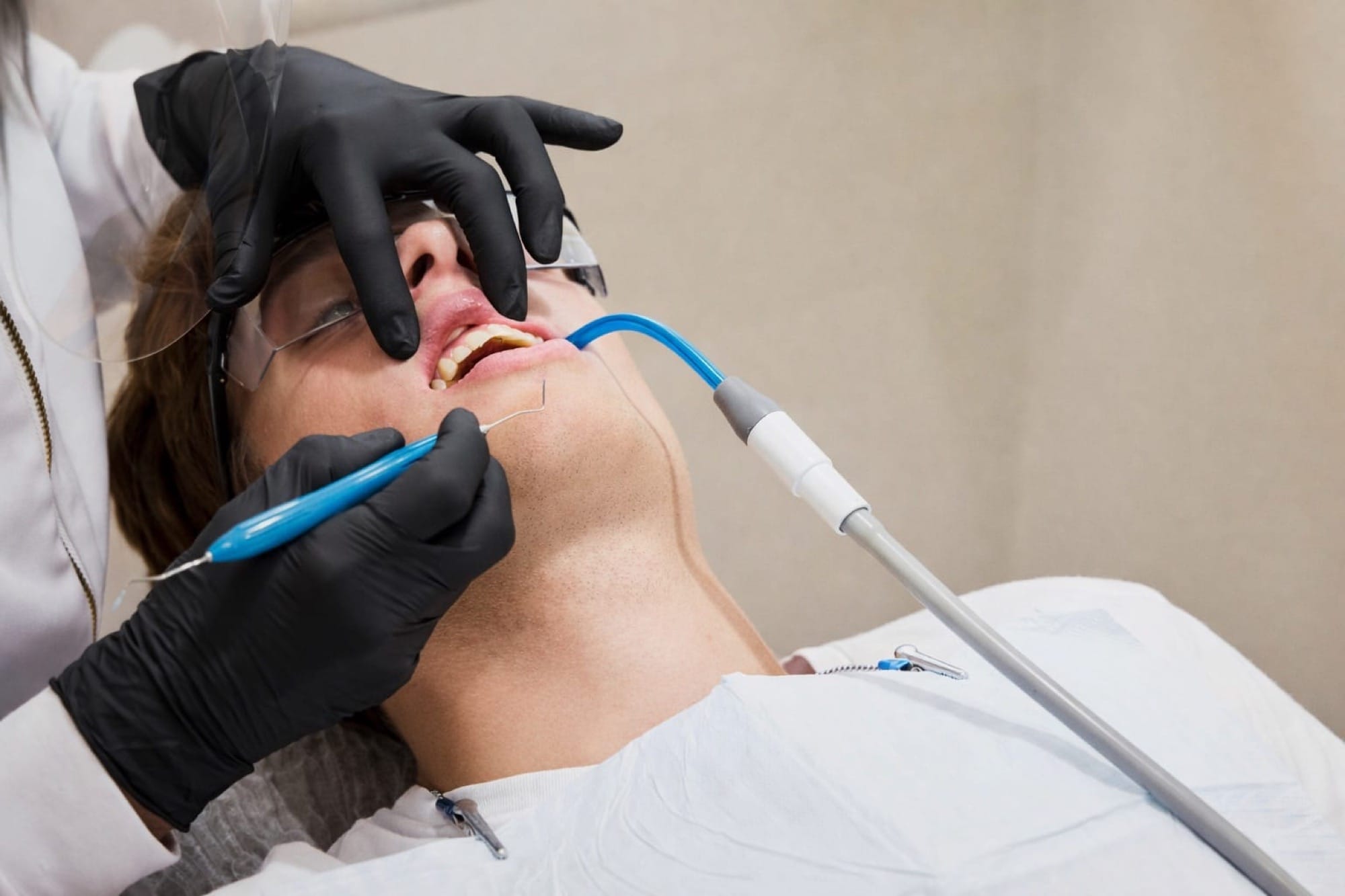 Professionelle Zahnreinigung: Eine Patientin wird mit einem Gerät behandelt, während eine Fachkraft präzise arbeitet.